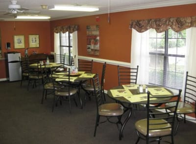 Dining area with tables and chairs in a warm-colored room