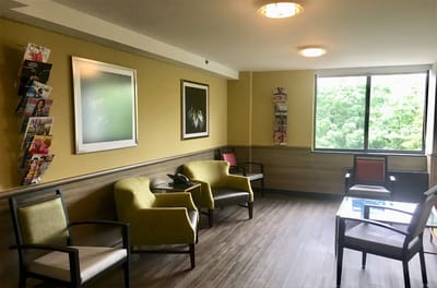 Bright common area with seating and magazine rack