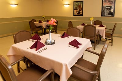 Dining area set for a meal with tables and chairs