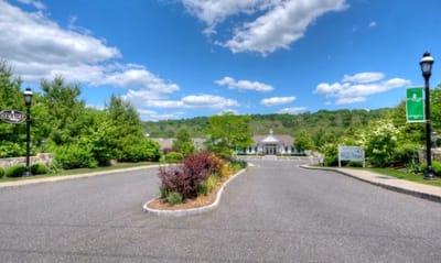 Driveway leading to a senior living facility with landscaped gardens