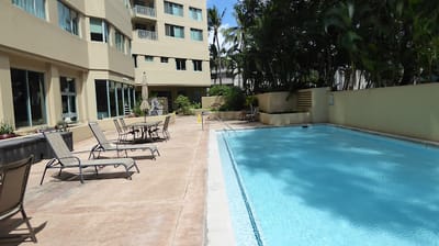 Outdoor pool area with lounge chairs and surrounding greenery