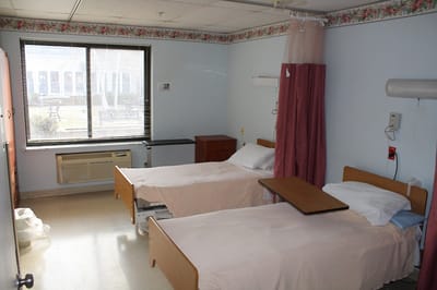 A shared resident room with two beds and a window
