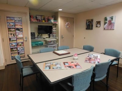 A common area in a senior living facility with tables and chairs