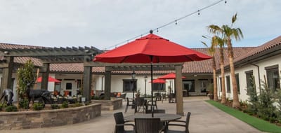 Outdoor patio area with red umbrellas and seating