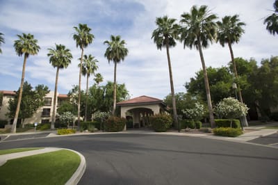 Entrance of a senior living facility with palm trees