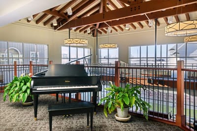 Interior view of a common area with a piano and plants