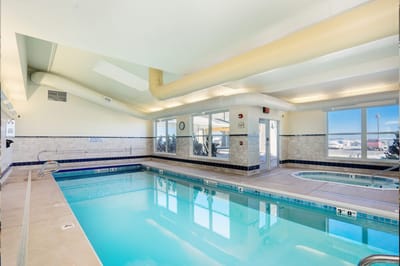 Indoor swimming pool with large windows and lounge area