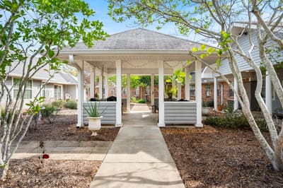 Covered outdoor seating area surrounded by greenery
