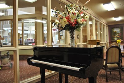 A grand piano with floral arrangement in a common area
