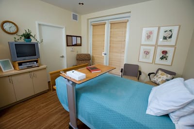 A cozy resident room with a bed and chairs