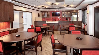Bright dining room with round tables and red chairs