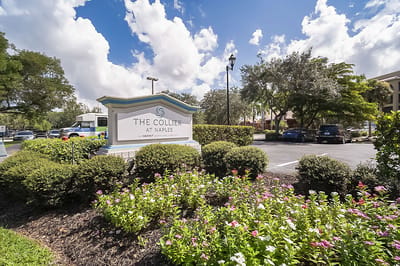 Exterior sign for The Collier at Naples with landscaping
