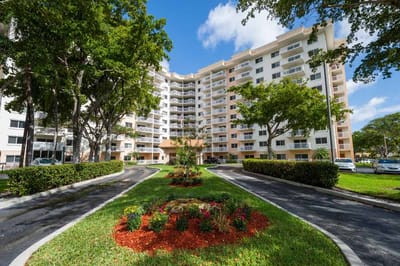 Exterior view of The Court at Palm Aire surrounded by landscaping