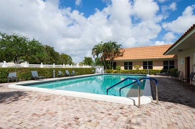 Outdoor pool surrounded by lounge chairs and landscaping