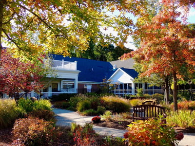Outdoor view of a senior living facility surrounded by colorful autumn trees