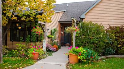 Entrance of a senior living facility with colorful flowers