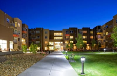 Exterior view of the facility at dusk with landscaped walkways