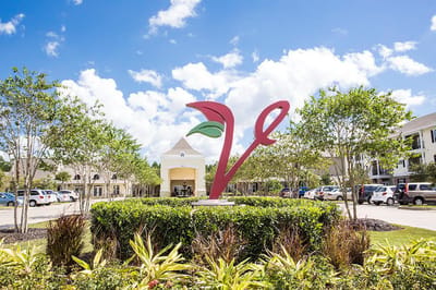 Logo of The Verandah Retirement Community in a landscaped area