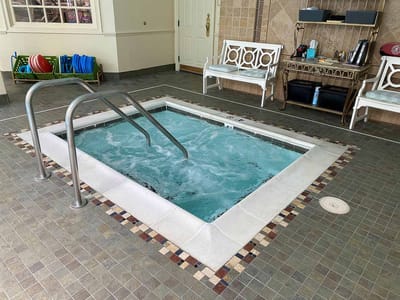 Indoor hydrotherapy hot tub with benches nearby