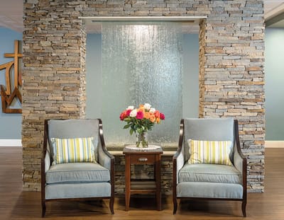 Cozy interior seating area with stone wall and water feature