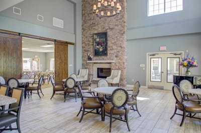 Spacious common area with dining tables and a fireplace