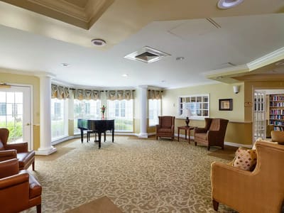 Common area with seating and piano in a well-lit space