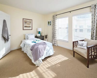 Cozy private bedroom with bedding and natural light