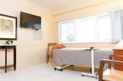 A well-appointed resident room with bed and TV