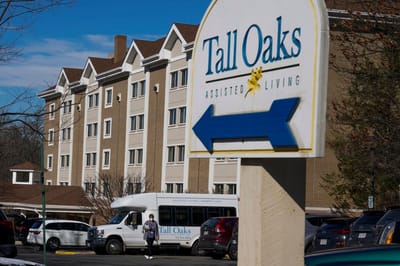 Sign for Tall Oaks Assisted Living with facility in background