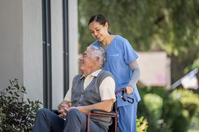 Caregiver assisting a resident outdoors