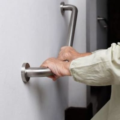 Hands gripping a safety grab bar installation