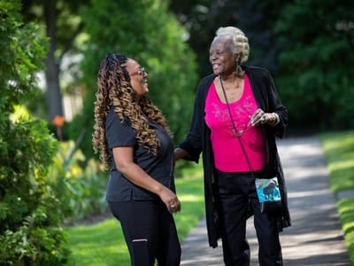 Staff member chatting with a resident in a garden