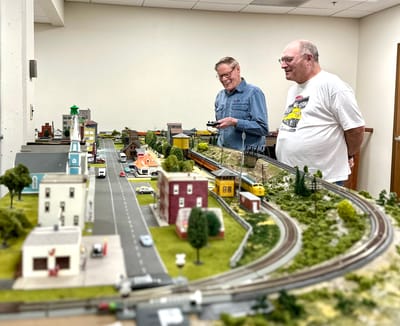 Residents enjoying a model train setup in an activity room