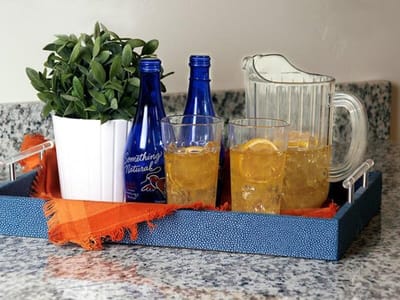 A tray with drinks and a plant on a countertop