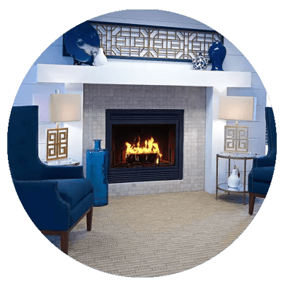 Cozy common area with blue chairs and a fireplace