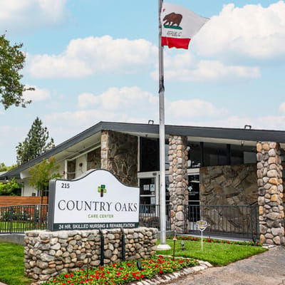 Exterior view of Country Oaks Care Center with a flag