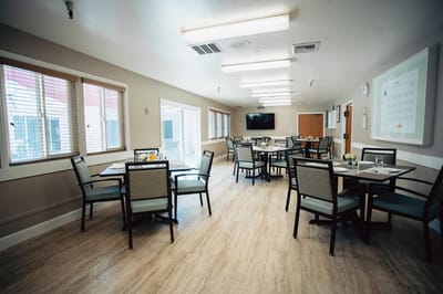 Well-lit dining area with tables and chairs