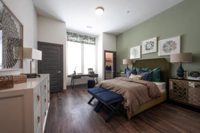 A well-decorated resident room with a bed and desk