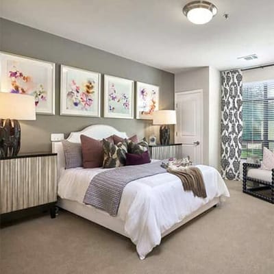 Well-decorated private resident room with bed and artwork