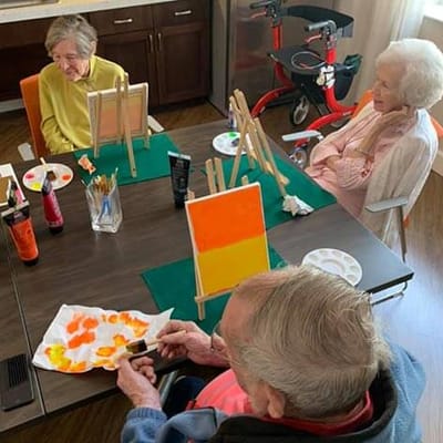 Heartis Longview Assisted Living, memory care in Longview, TX — Seniors painting on canvases during an art activity