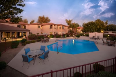 Outdoor pool area with seating and landscaped gardens