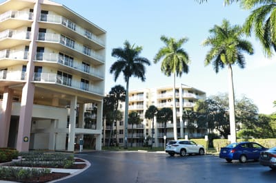 Exterior view of a senior living facility with palm trees
