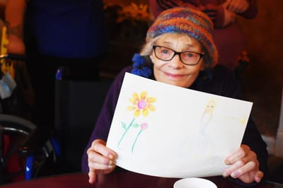 Resident proudly displays a colorful drawing