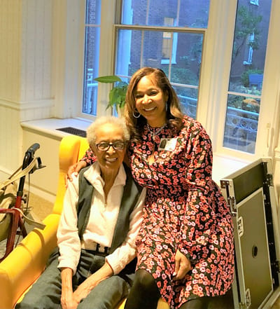 A staff member sitting with a resident in a common area