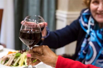 Residents toasting with wine over a meal