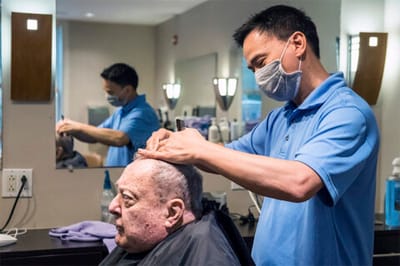 A resident receiving a haircut in a salon setting