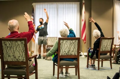 Residents participating in an exercise class in a common area