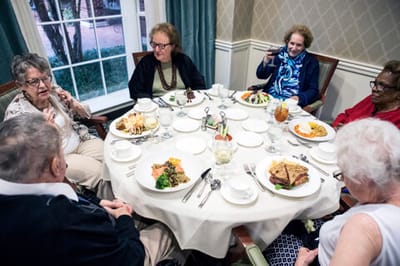 Residents enjoying a meal together at a dining table