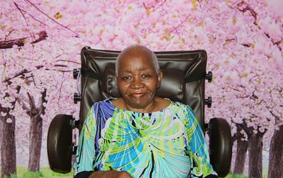 Landmark Nursing & Rehabilitation Ctr of West Mon, Nursing Home in West Monroe, LA — Woman seated in a wheelchair against a pink floral backdrop