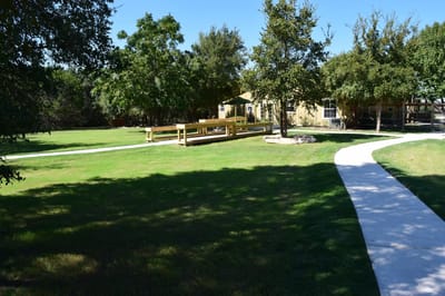 Outdoor pathway leading to a facility with greenery